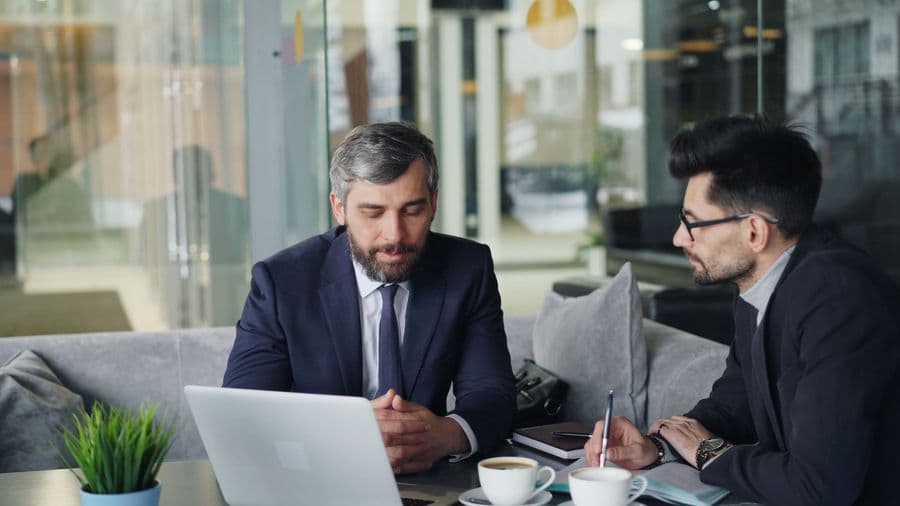 Two consultants reviewing work on a laptop